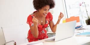 Excited Woman Working At Desk In Design Studio