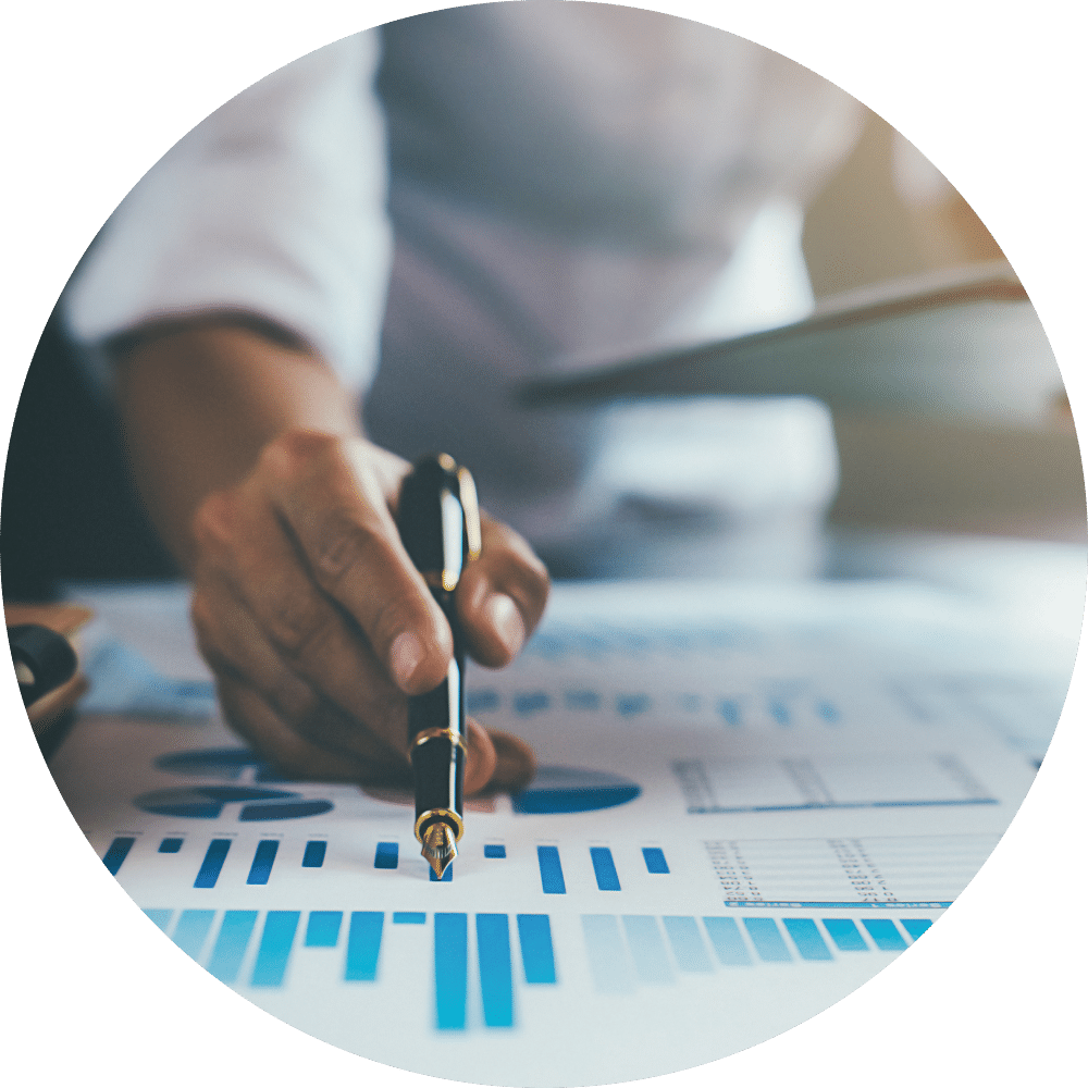 A man pointing to a chart within a document on a table.