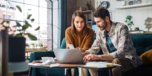 A girl and a guy looking at a laptop together at their tax information