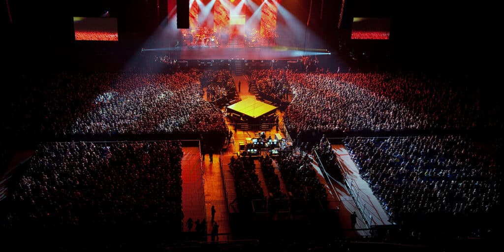 Overhead view of a huge concert at an indoor venue with thousands of fans