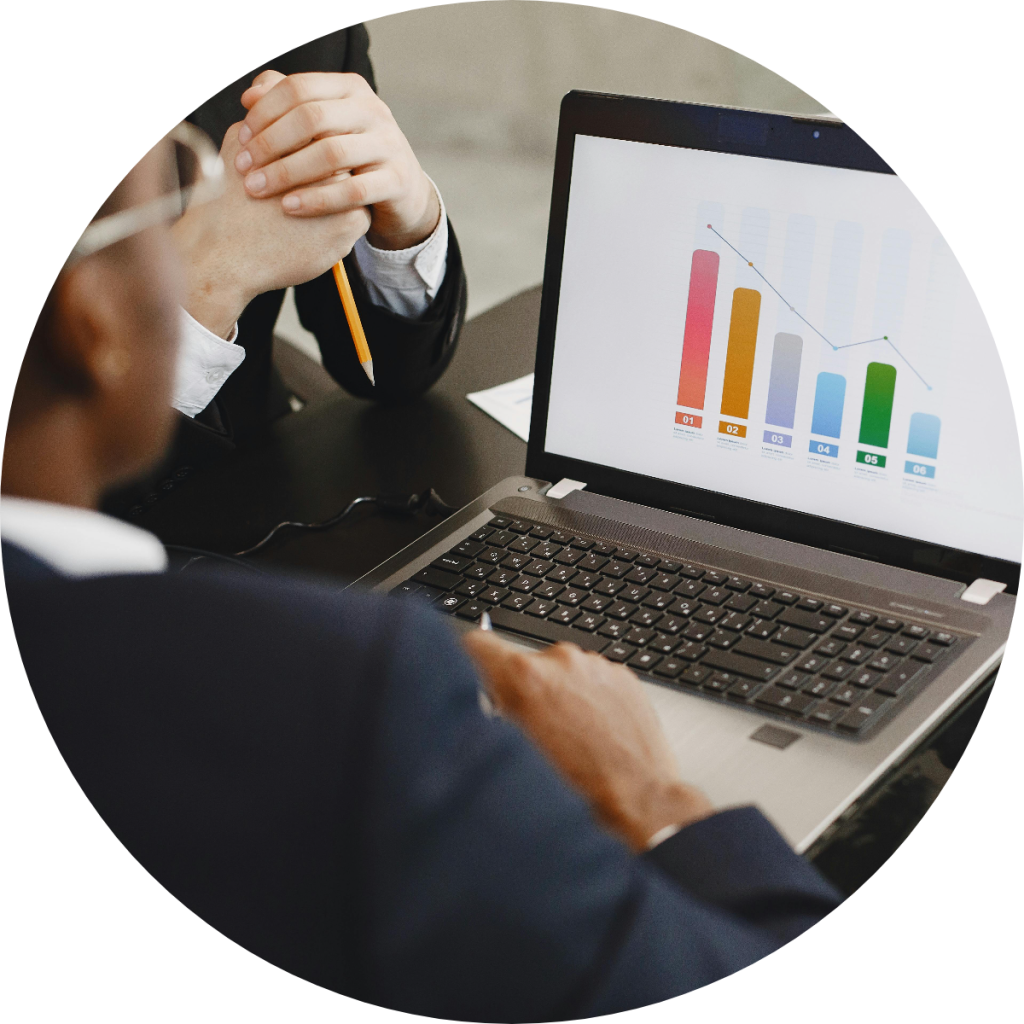 Business professionals reviewing colorful bar chart and trend line on laptop screen during financial data analysis or investment performance review meeting
