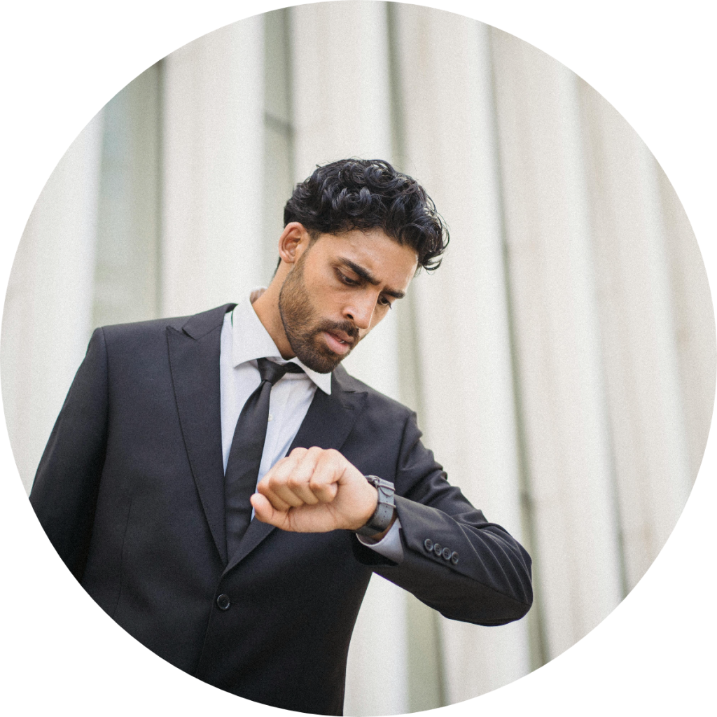 Professional businessman in suit checking wristwatch outside office building, concept of tax deadline, financial appointment, or time-sensitive business meeting