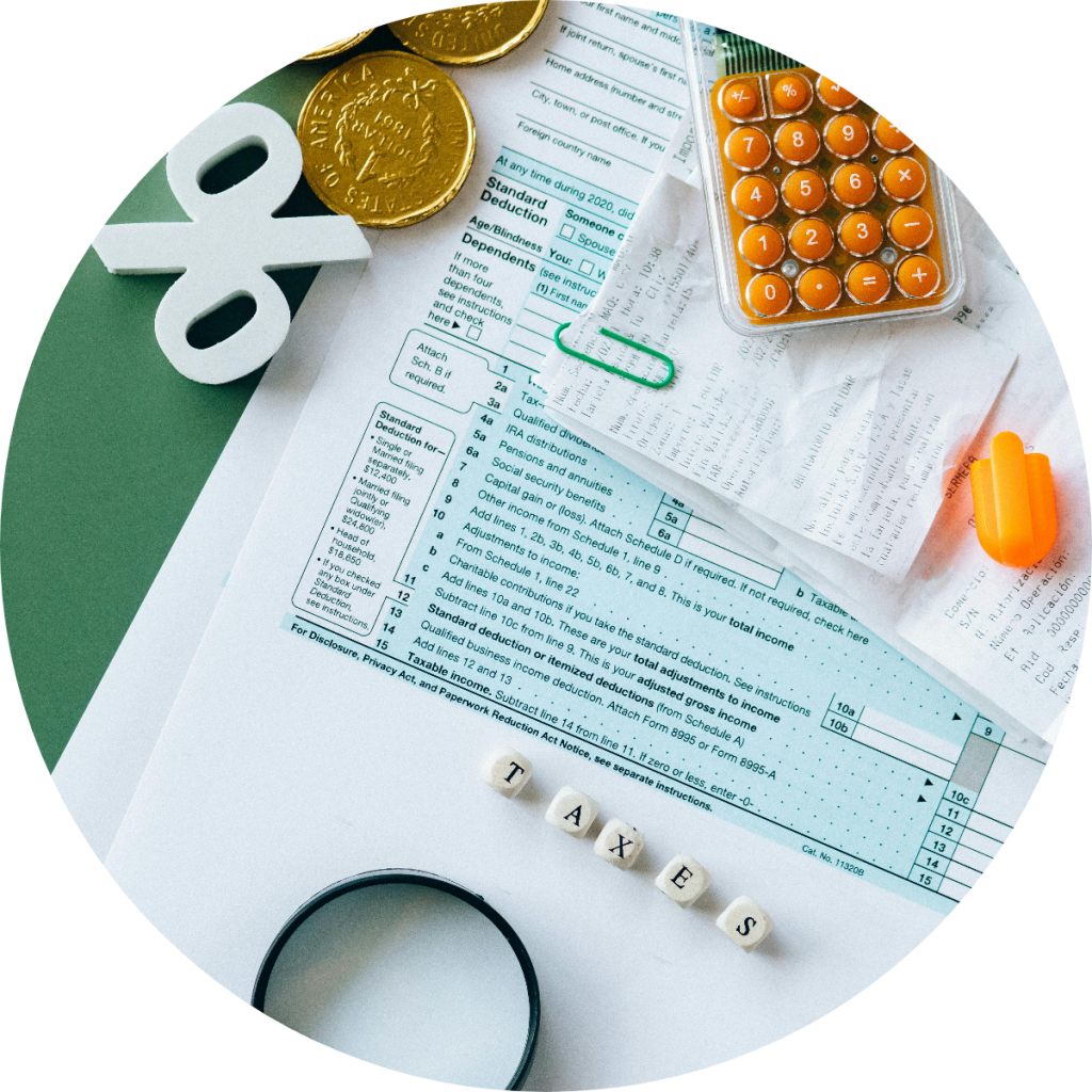 IRS tax form with standard deduction, taxable income, and adjusted gross income sections displayed alongside calculator, gold coins, percentage symbol, and letter tiles spelling TAXES for federal tax filing season