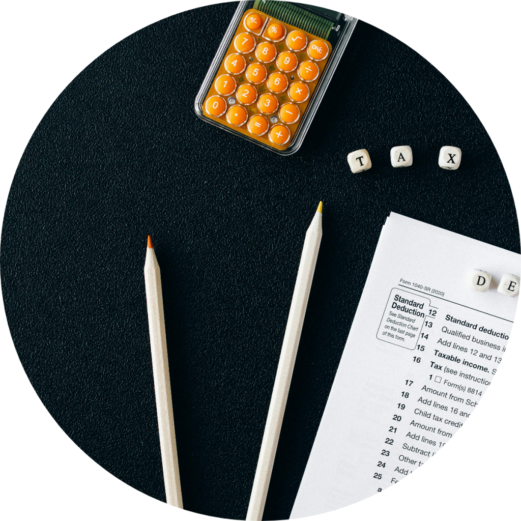 IRS Form 1040-SR standard deduction and taxable income sections with orange calculator, two pencils, and letter tiles spelling TAX on dark background for senior tax return preparation